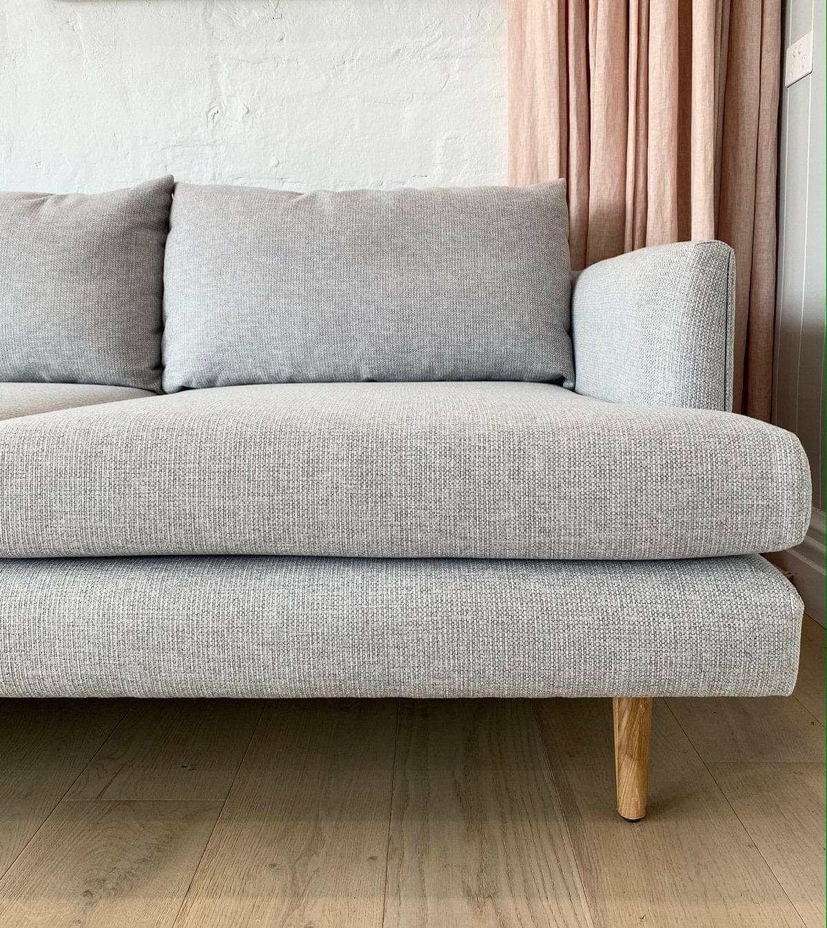 Custom Norsu Sofa 2.5 seater in Wells Driftwood fabric with wooden legs in a modern living room setting