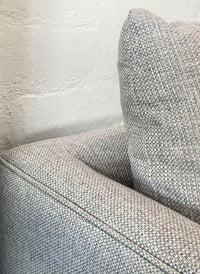 Close-up of Custom Norsu Sofa 2.5 seater in Wells Driftwood textured fabric showing detailed upholstery and cushioned armrest.