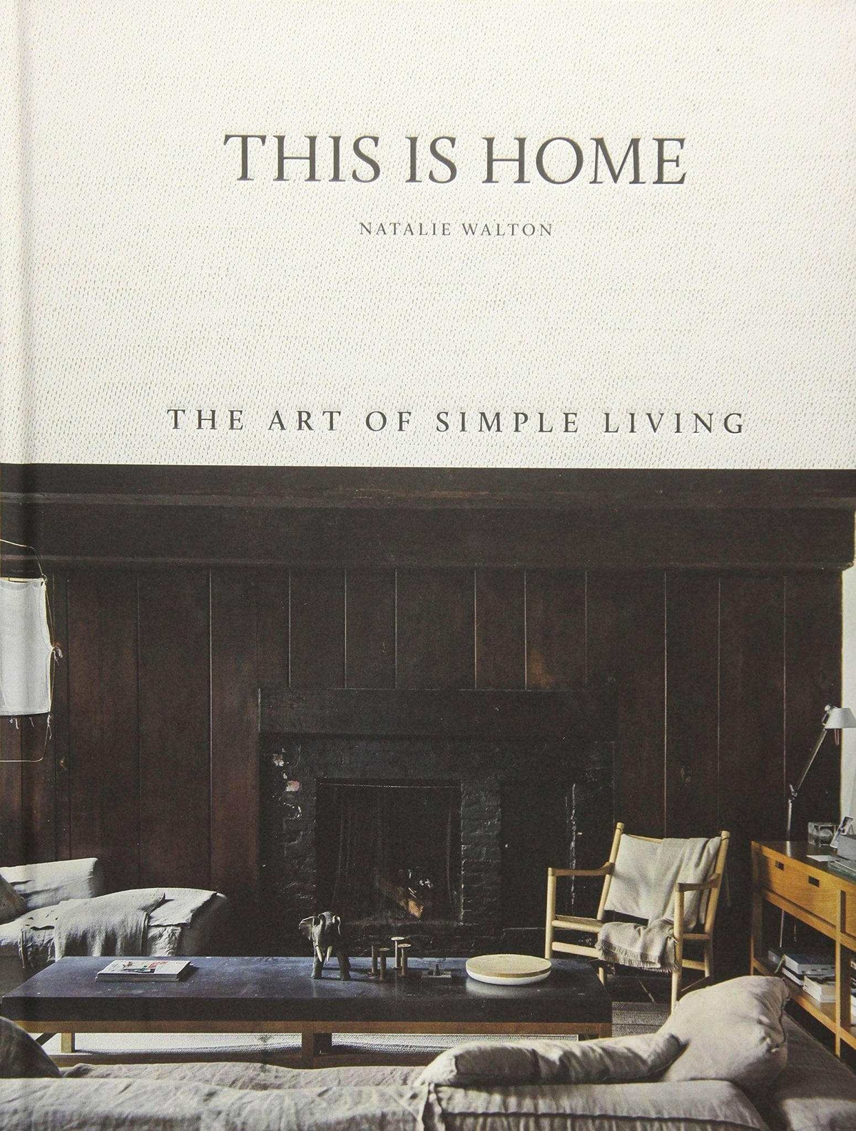 Cover of "This Is Home, The Art of Simple Living" by Natalie Walton featuring a cozy living room with wooden paneling and comfortable furniture