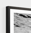 Close-up of black framed Middle of Nowhere Tropical Swim photographic print with abstract water design.