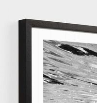 Close-up of black framed Middle of Nowhere Tropical Swim photographic print with abstract water design.