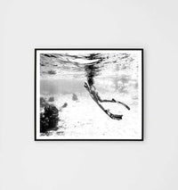 Black and white Middle of Nowhere tropical swim print framed in black, showing underwater swimmer with fins in a modern style