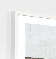 Framed minimalist photographic print titled Middle Of Nowhere 'Walkway' in a white frame behind glass, measuring 81 x 101cm.