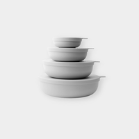 Set of four smoke-colored nesting bowls with snap-tight lids, lightweight and BPA-free, designed for versatile kitchen use and easy storage.
